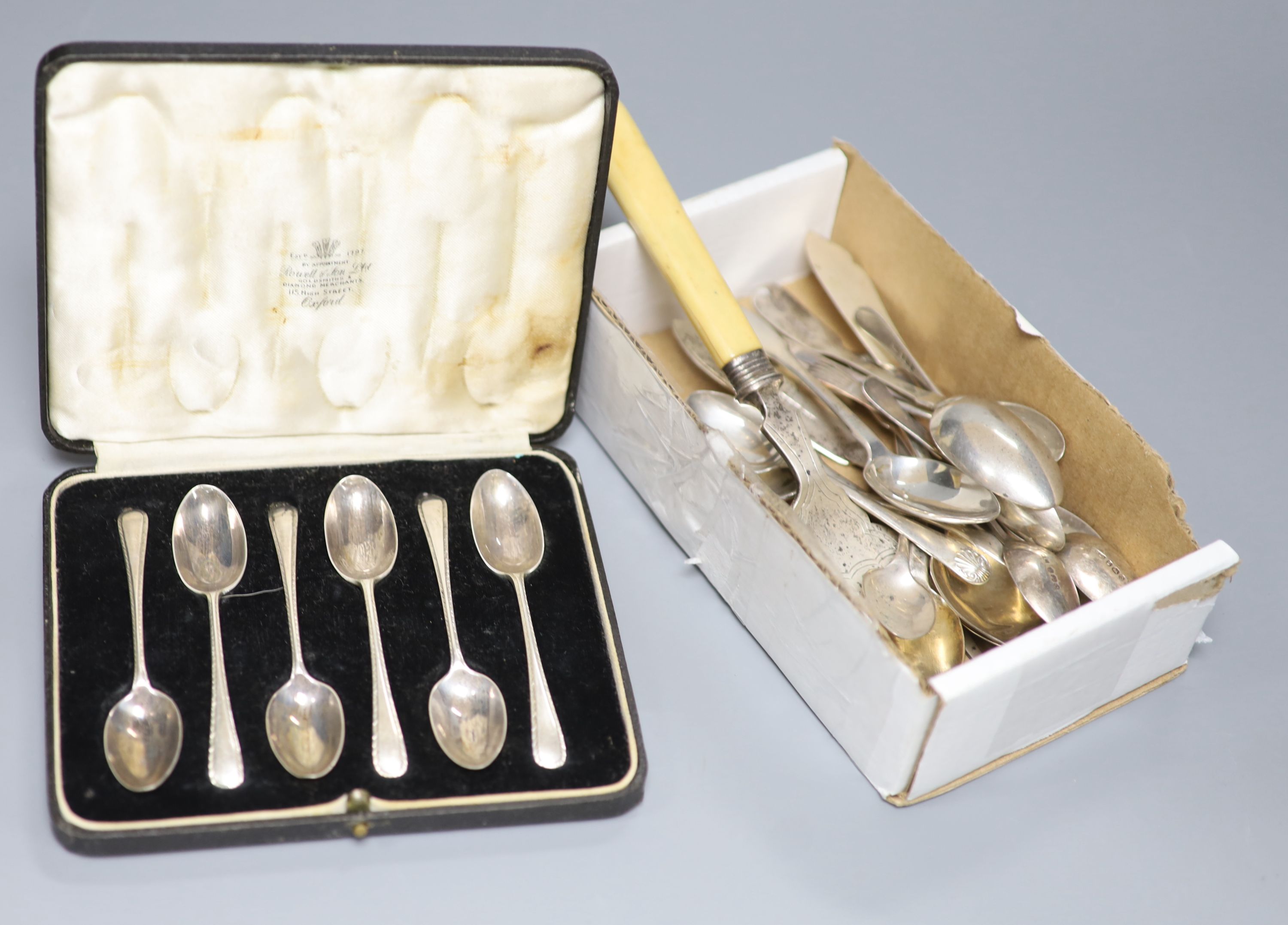 A set of nine George IV silver fiddle pattern teaspoons, London , 1821, two later sets of six silver teaspoons, one cased, five other silver teaspoons, a silver butter knife and an ivory handled silver serving fork